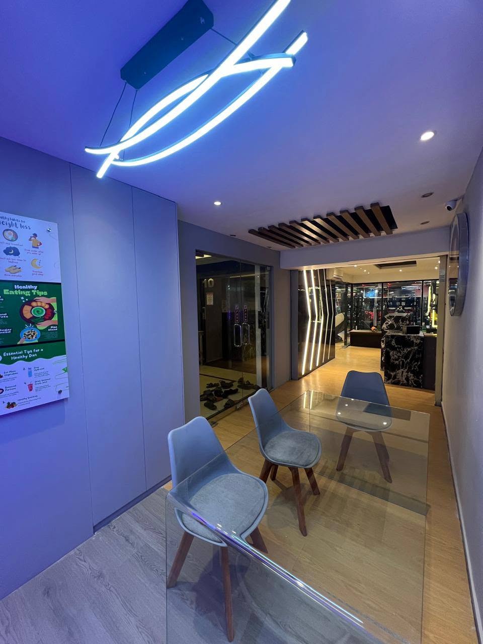 Members' lounge with glass consultation table and seating beside reception