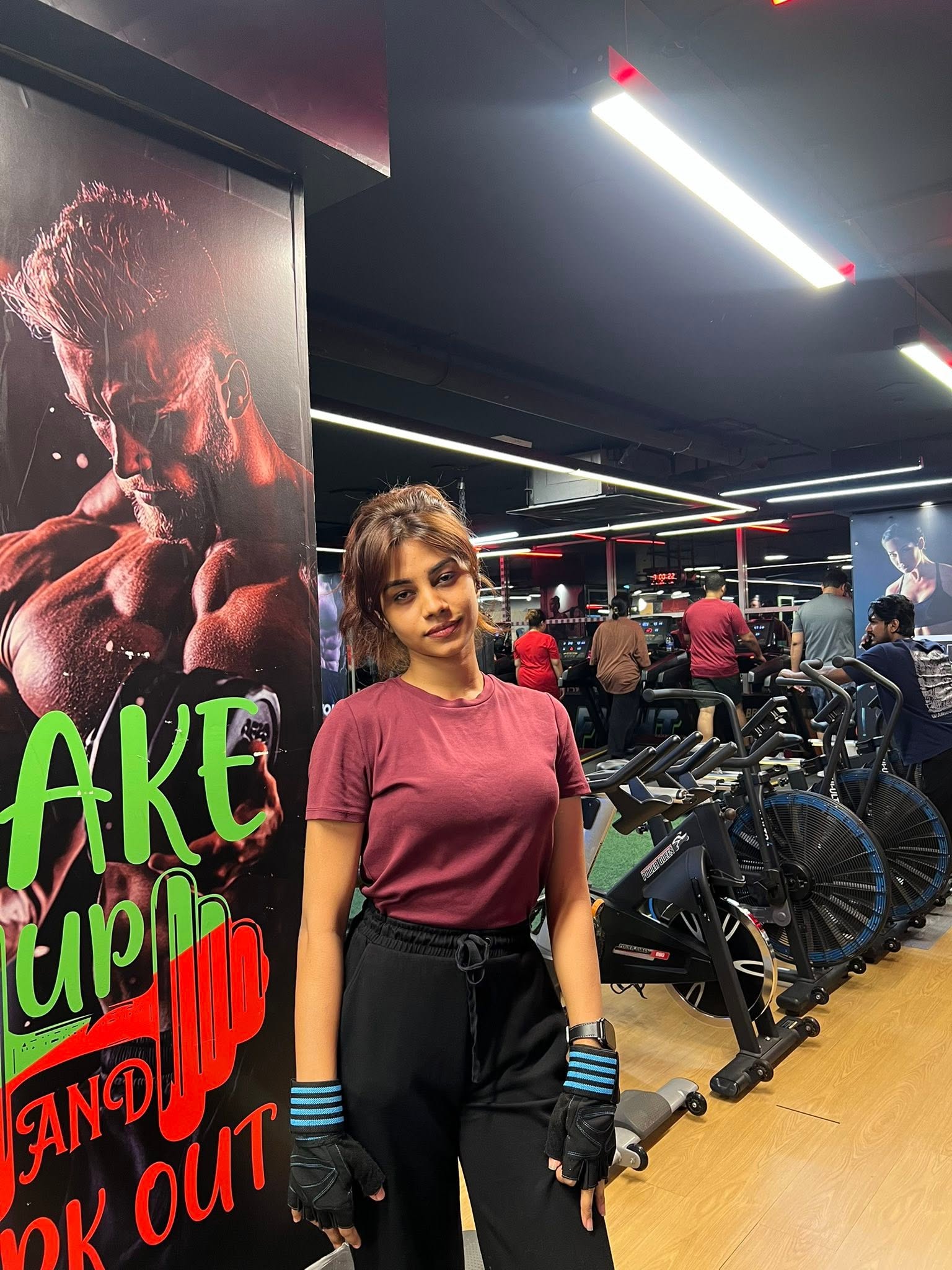 Member standing beside the air bikes